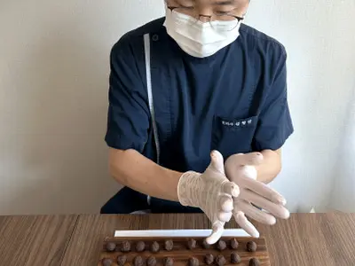 나눈 공진단 반죽을 두 손바닥 사이에서 둥글게 빚는 모습