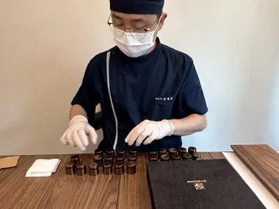 공진단을 담은 개별 청병의 뚜껑을 닫으며 포장을 마무리하는 모습